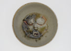 Ceramic bowl with abstract face design on a white background